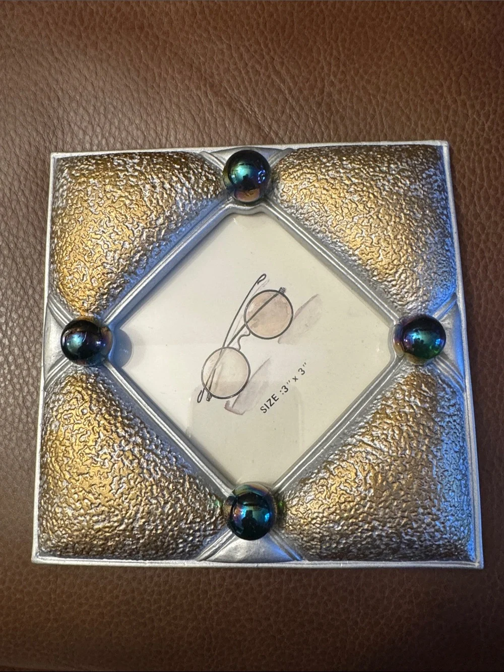 Gold and gray textured picture frame with purple iridescent marbles